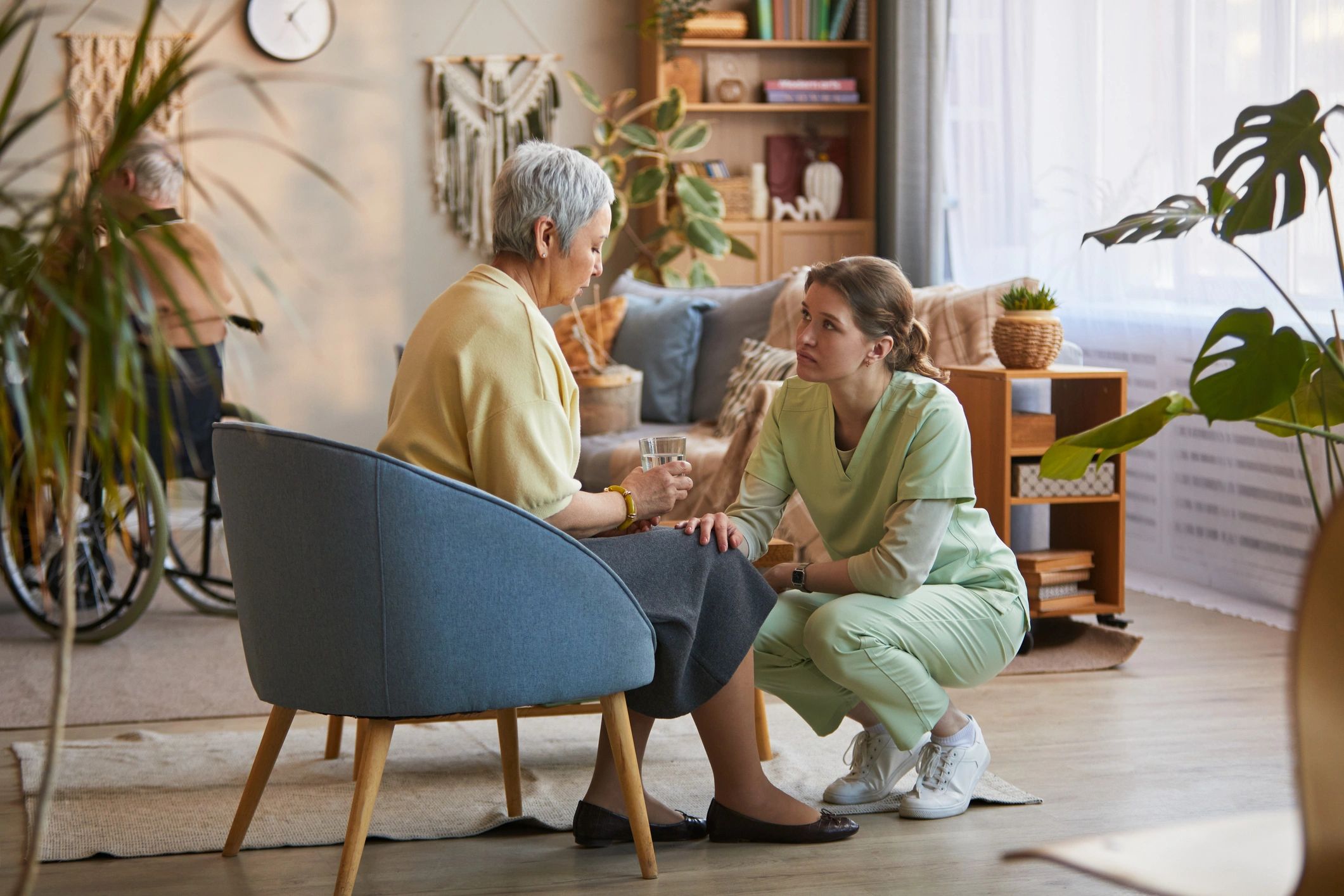 Caregiver speaking with a senior woman during a supportive home care visit